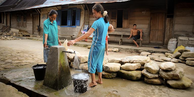 In some provinces of Indonesia, the daily chore of carrying bucket loads of water from a source to home has fallen on the shoulders of the village's women. Photo credit: ADB. 