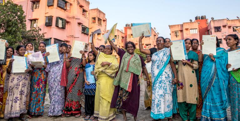 Women beneficiaries of showing off their housing lease documents. Photo credit: ADB.