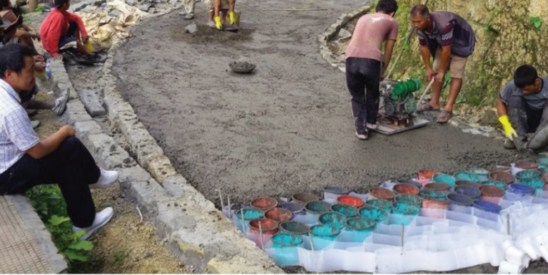 Plastic cells made from plastic waste are filled with concrete and compacted by a plate vibrator to build roads. Photo credit: ADB.