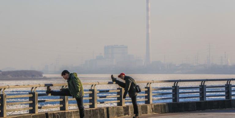 Men exercising against the backdrop of an industrial development in the People's Republic of China. Photo credit: ADB.