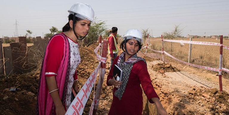 Junior engineers Neelam Meena (left) and Nisha Beniwal (right) check on the progress of trenches being dug for a new sewer line. Female engineering students are offered internships to diversify the state’s workforce. Photo credit: Amit Verma, ADB. 