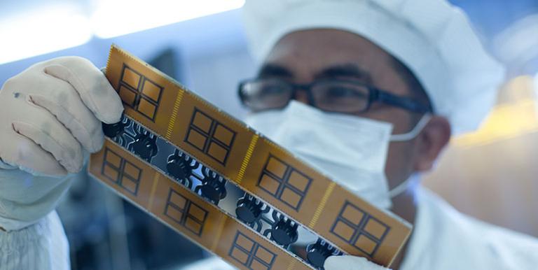 A student examines a printed circuit board at a polytechnic in Indonesia. Photo credit: ADB.